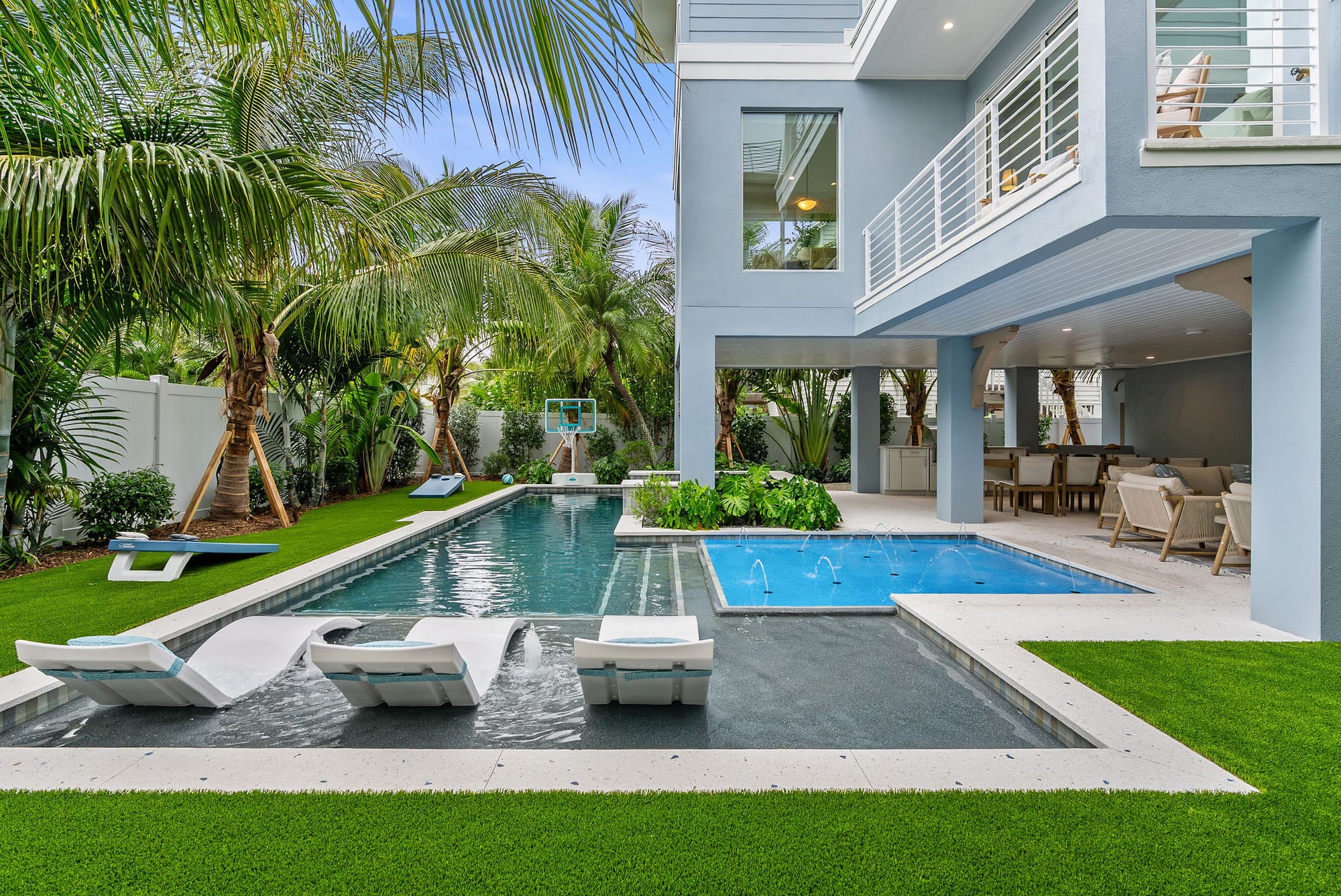 A custom pool with in-water sun shelf loungers, deck jets, and a covered lanai at 206 70th Street in Holmes Beach, FL.